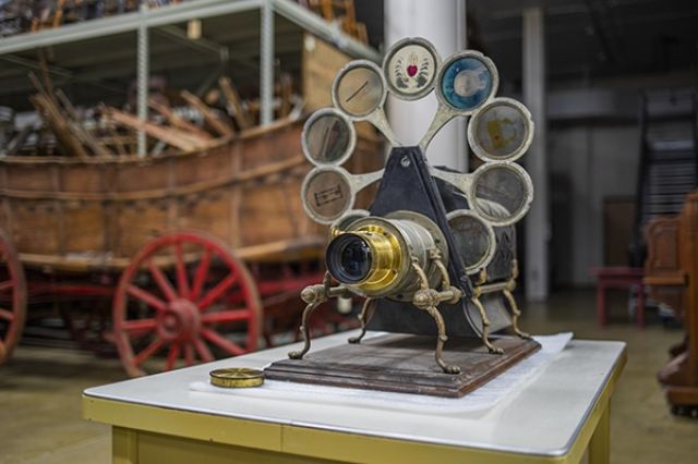 A cool looking old static image projector of some kind - it has disks on arms that rotate into a chamber in front of a light and behind a lense