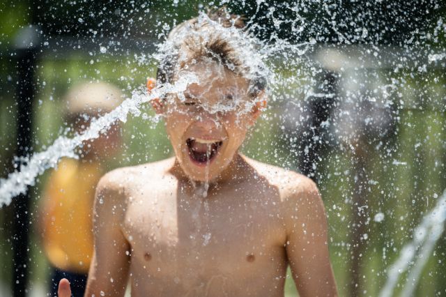 boy getting doused in the face with a stream of water