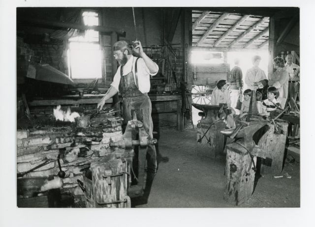 Image of the Blacksmith Shop with guests in 1972 from the Conner Prairie Museum archives.