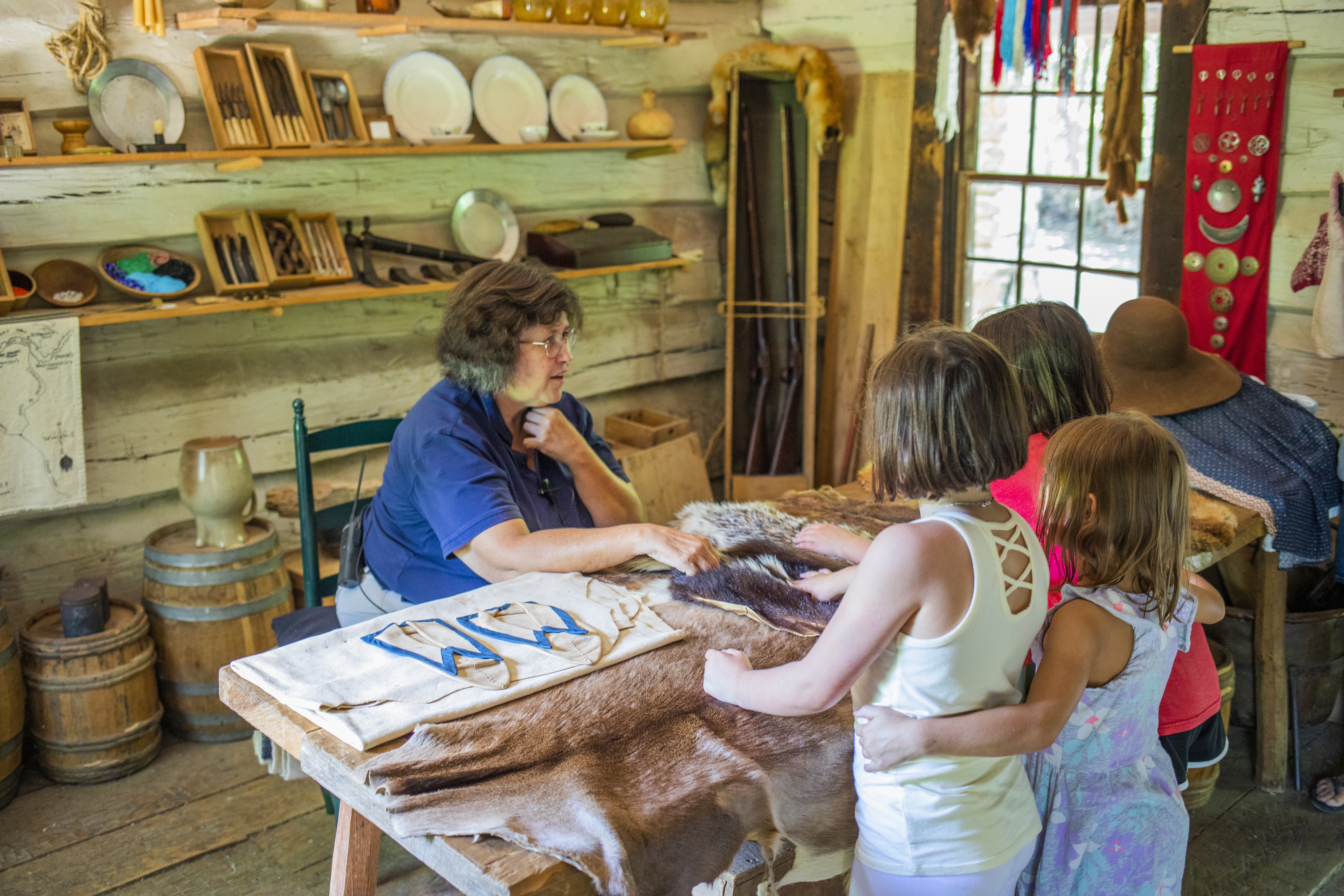 Inside the fur trader's cabin looking at different animal furs.