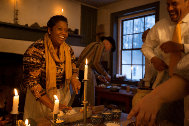 Folks enjoying themselves in a candle lit meal lots of happiness depicted 